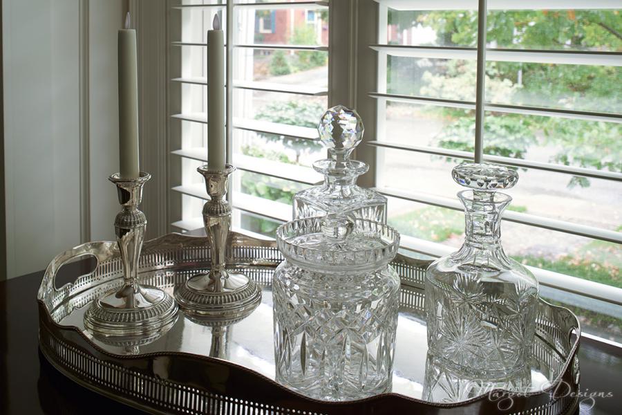 Silver tray with decanters and candles.